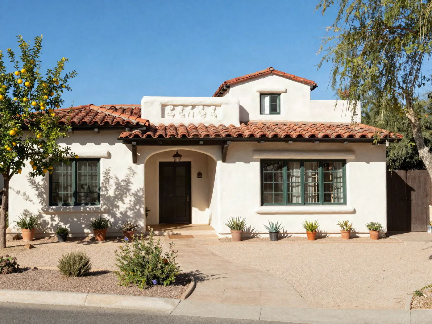 Spanish colonial home in Phoenix repainted in warm cream with dark bronze trim and a red tile roof