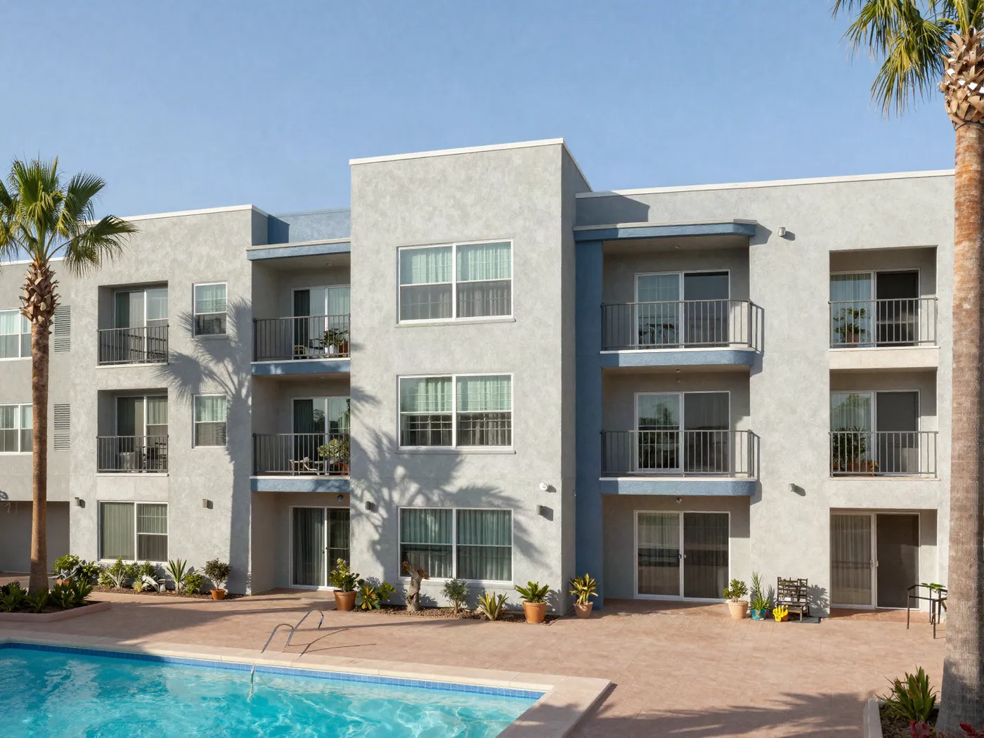 Three-story apartment community repainted in greige and slate blue